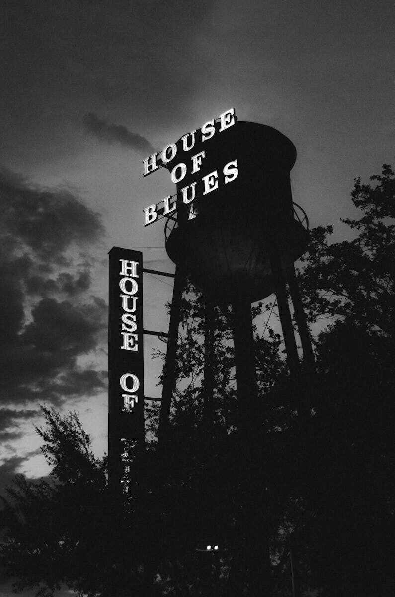 A moody black and white photo of the iconic House of Blues sign silhouetted against the sky.