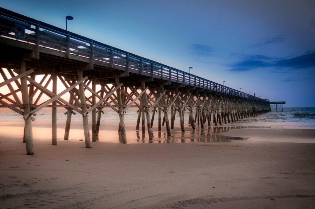 a long pier stretches out into the ocean