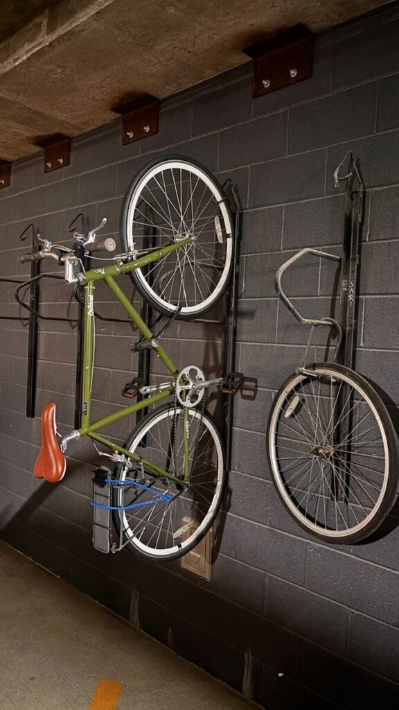 Green bicycle hanging on a brick wall.