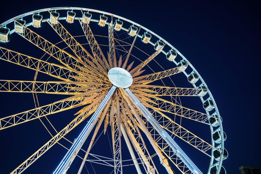 Low angle night shot of a brightly lit Ferris wheel in Gdańsk, Poland.