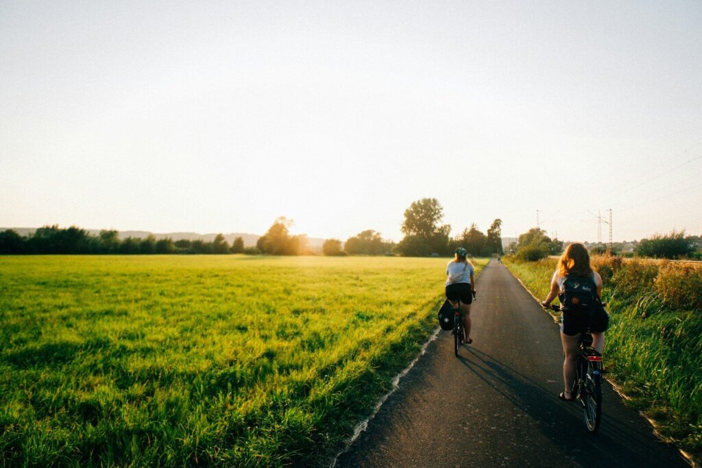 A couple of people riding bikes down a road