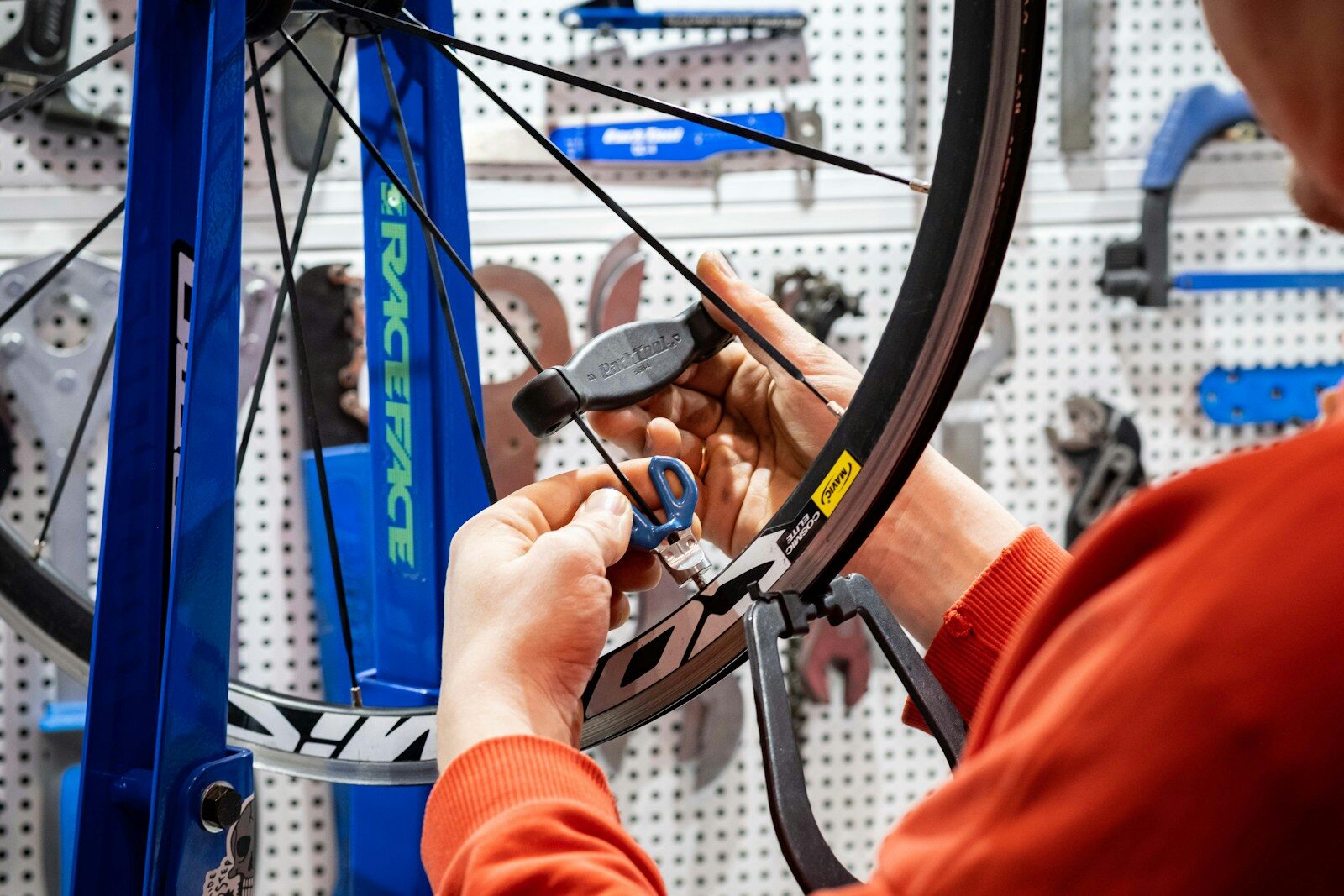 Photo by Anton Savinov a man working on a bicycle wheel in a shop