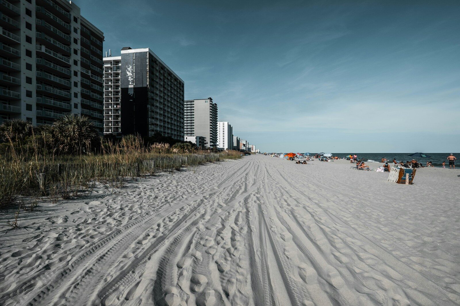 Photo by Zac Gudakov white sand beach near city buildings during daytime