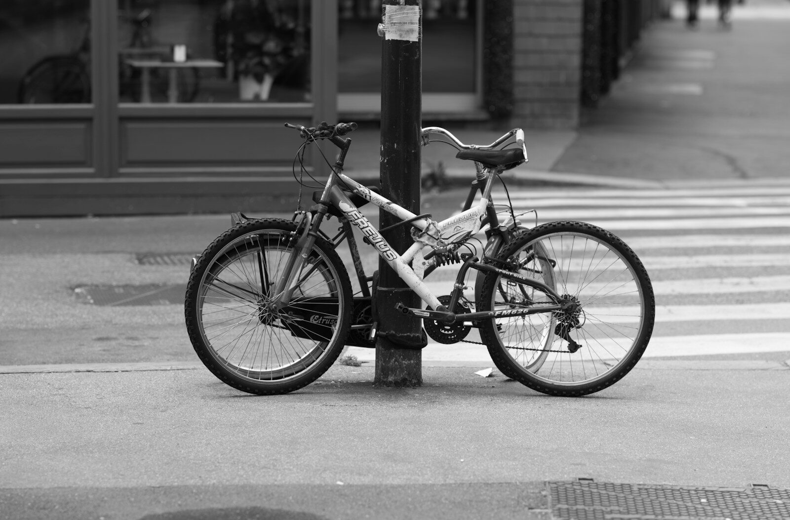 a bicycle chained to a pole on a city street