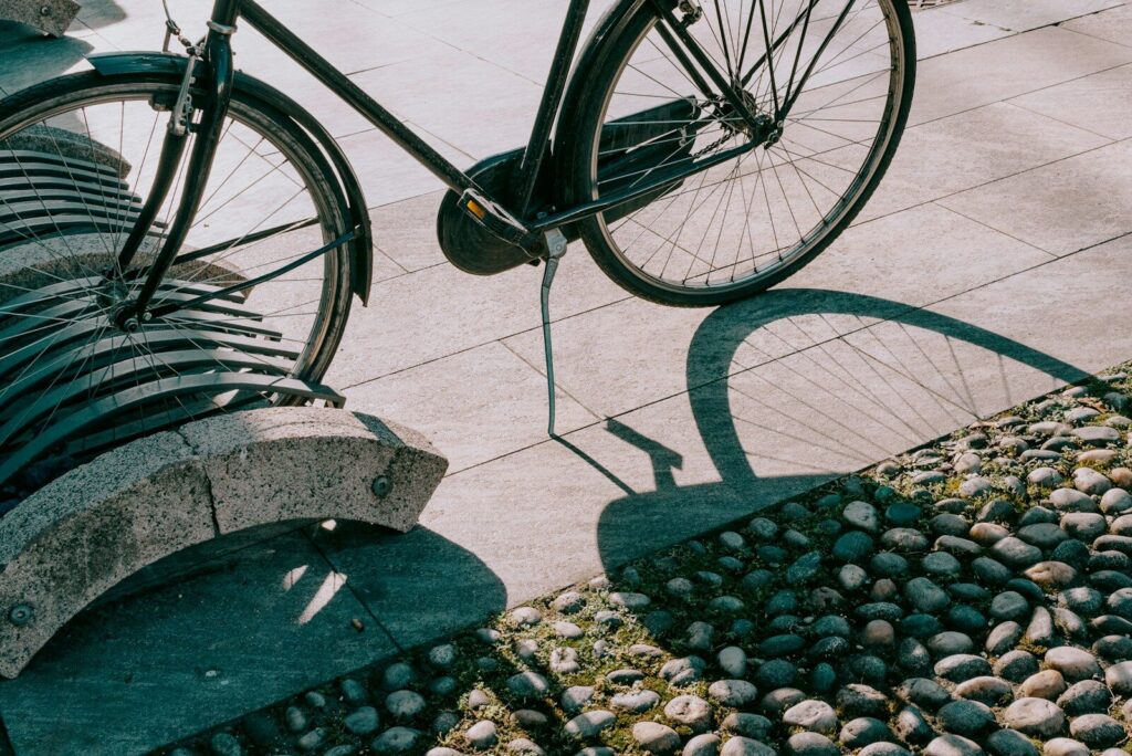 a bicycle parked next to a stone bench
