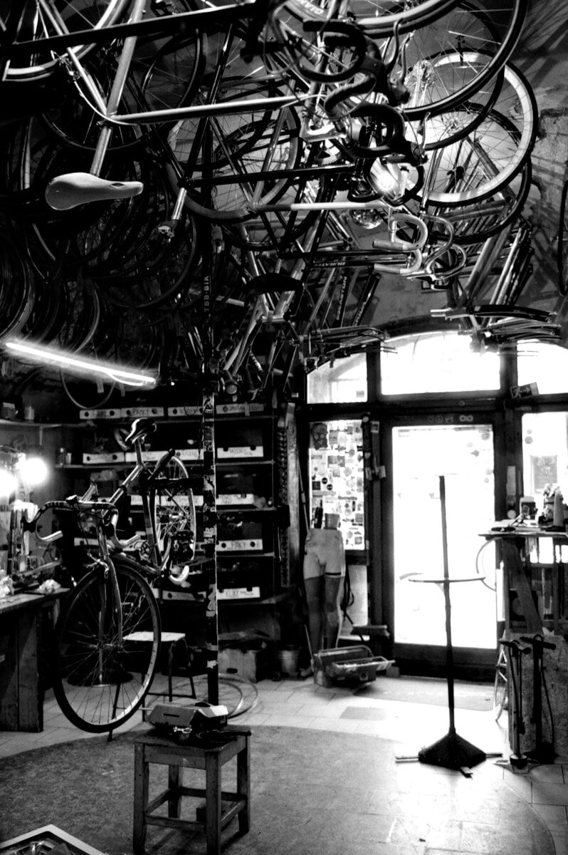 Photo by Lukáš Lehotský a room filled with lots of bikes hanging from the ceiling