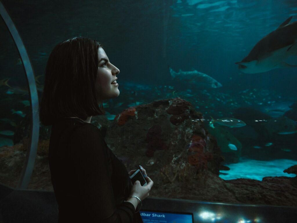 woman wearing black long-sleeved shirt facing the aquarium