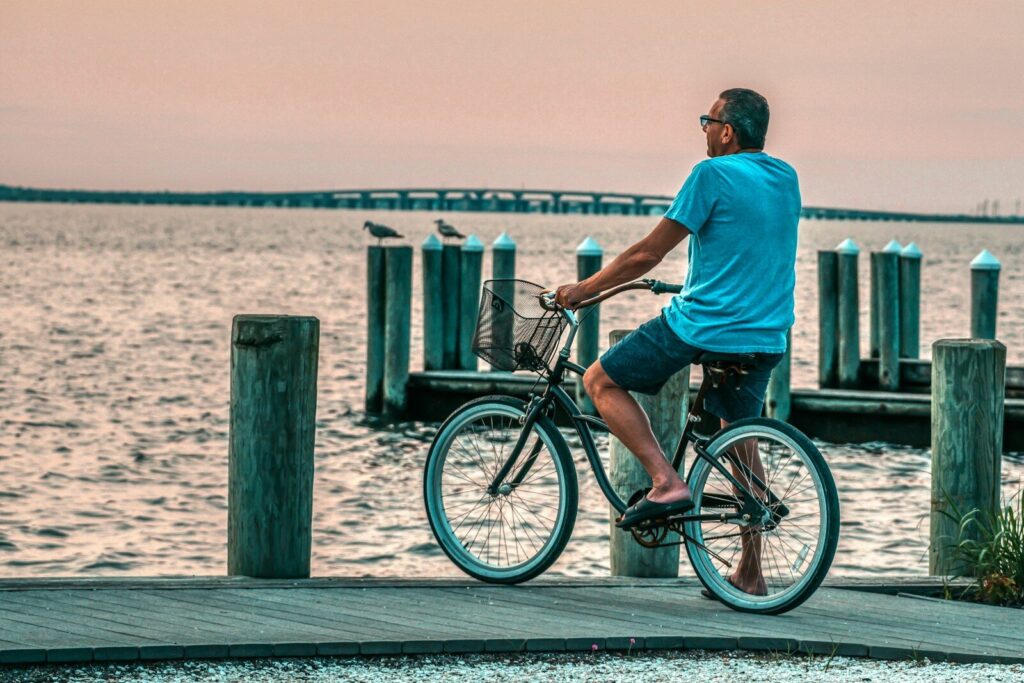A man riding a bike next to a body of water
