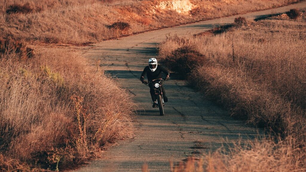a man riding a motorcycle on a dirt road